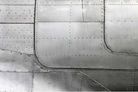 fine thread rivets tightened along the body of an aero plane